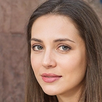 A woman with long brown hair and a serious expression is looking towards the camera, with an array of cooking equipment subtly visible in the background.