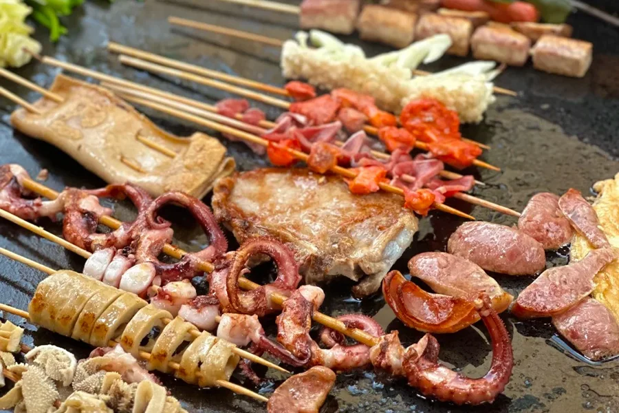 A variety of grilled ingredients are neatly arranged on the commercial griddle, including pork, beef, lamb, chicken, seafood, vegetables, etc., which are mouth-watering.